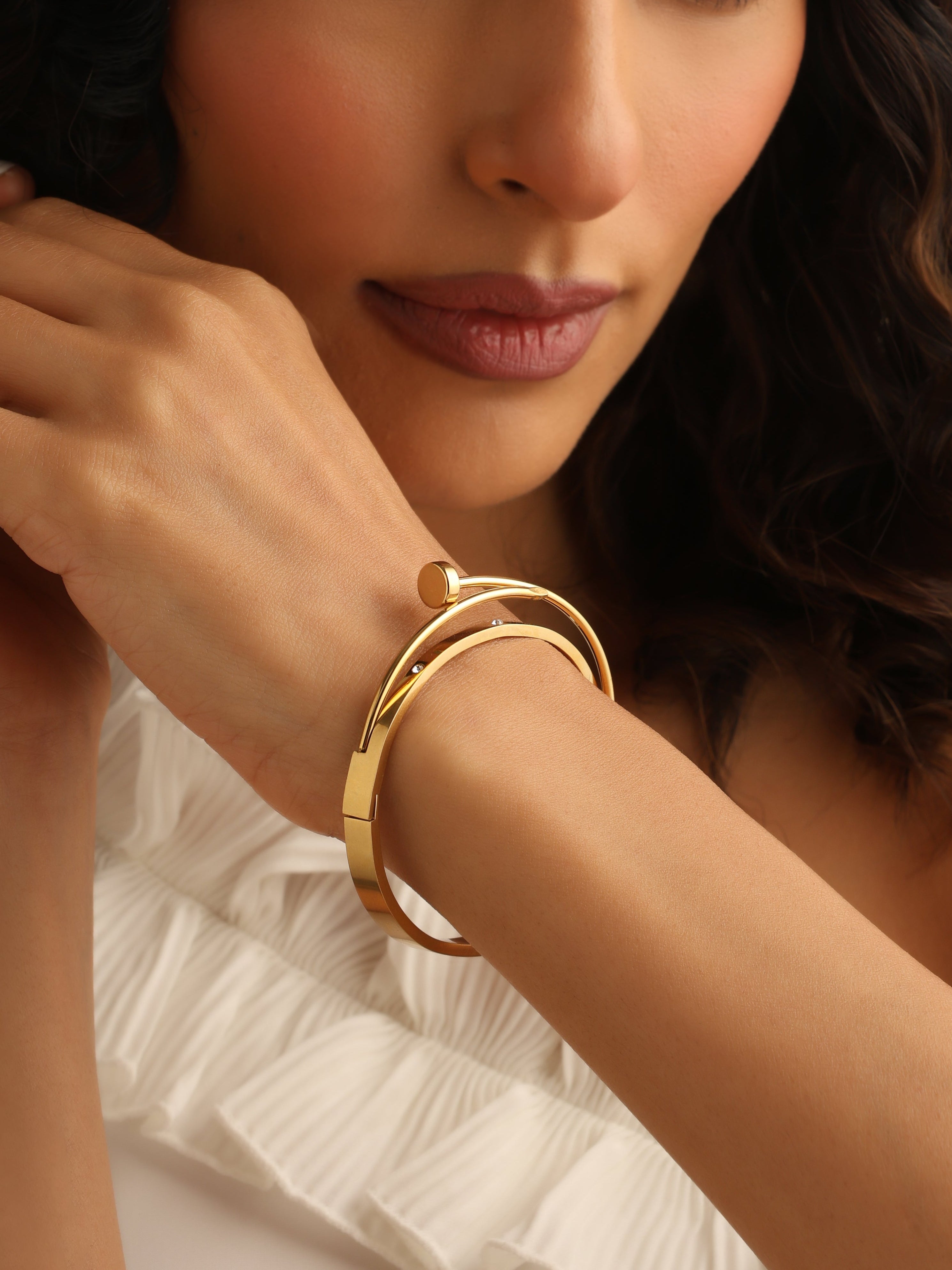 Woman wearing a gold bracelet with a soft focus background