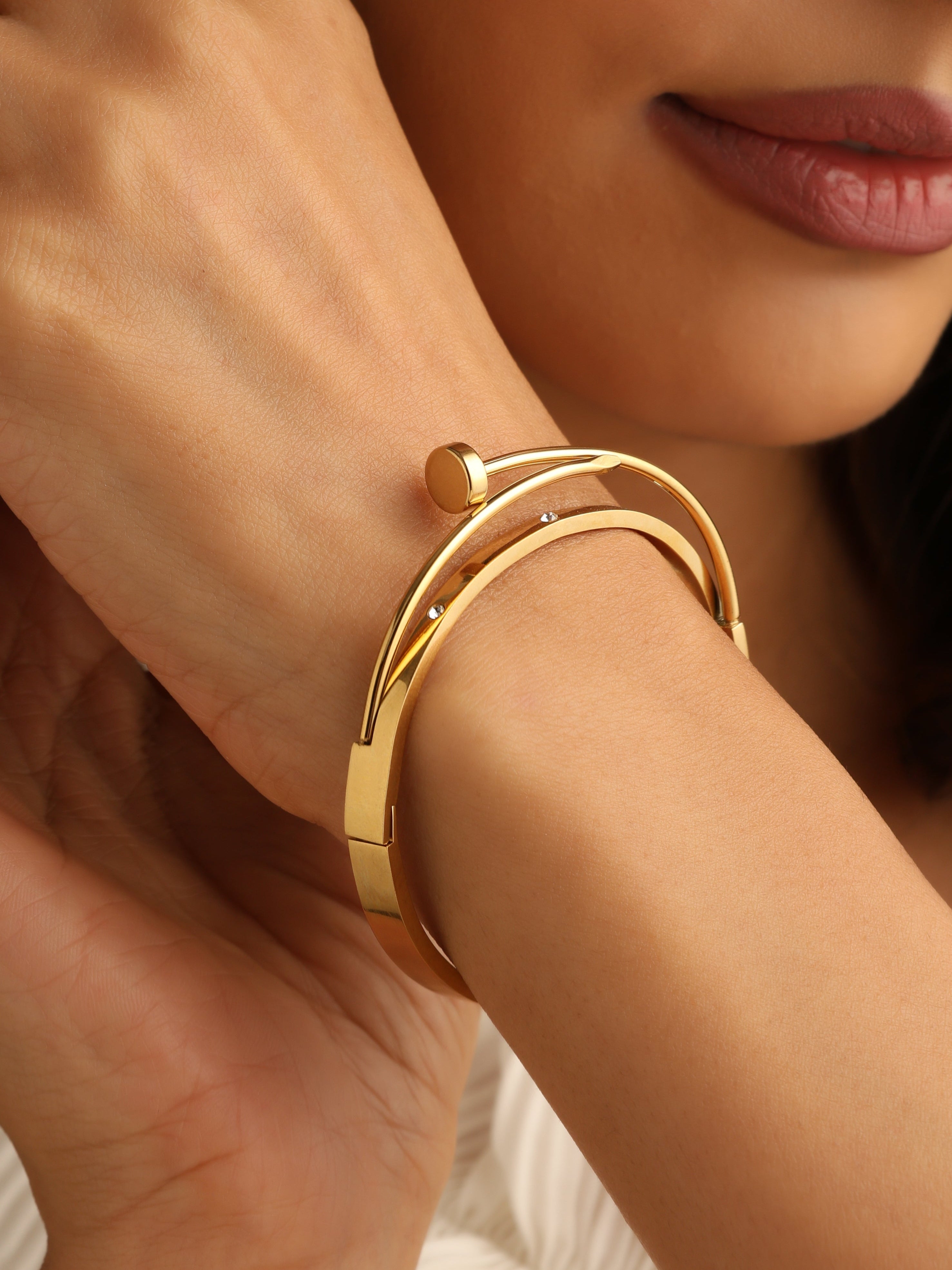Close-up of a person wearing a gold bracelet with a soft focus background