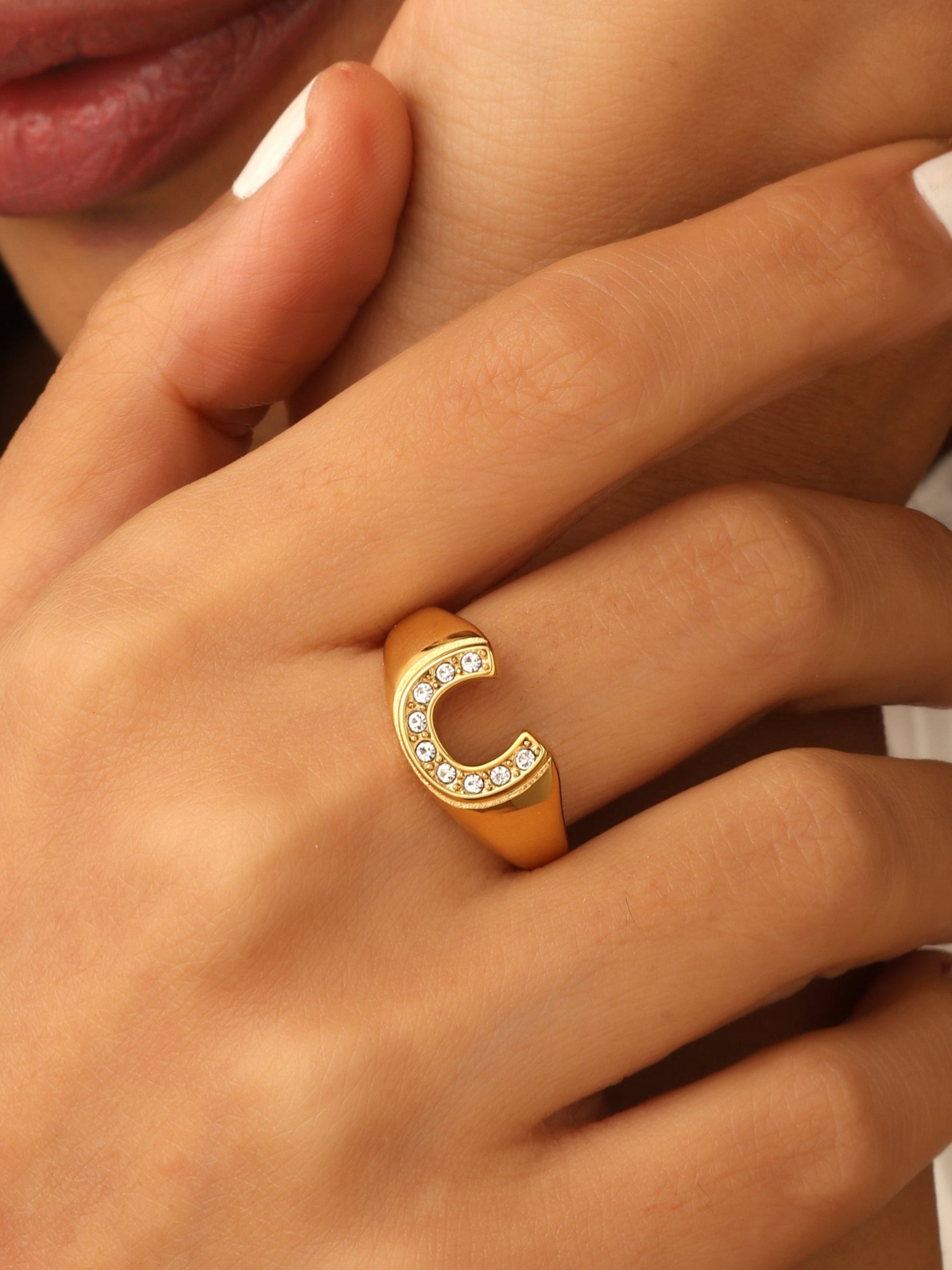 Gold ring with a crescent moon design on a person's finger