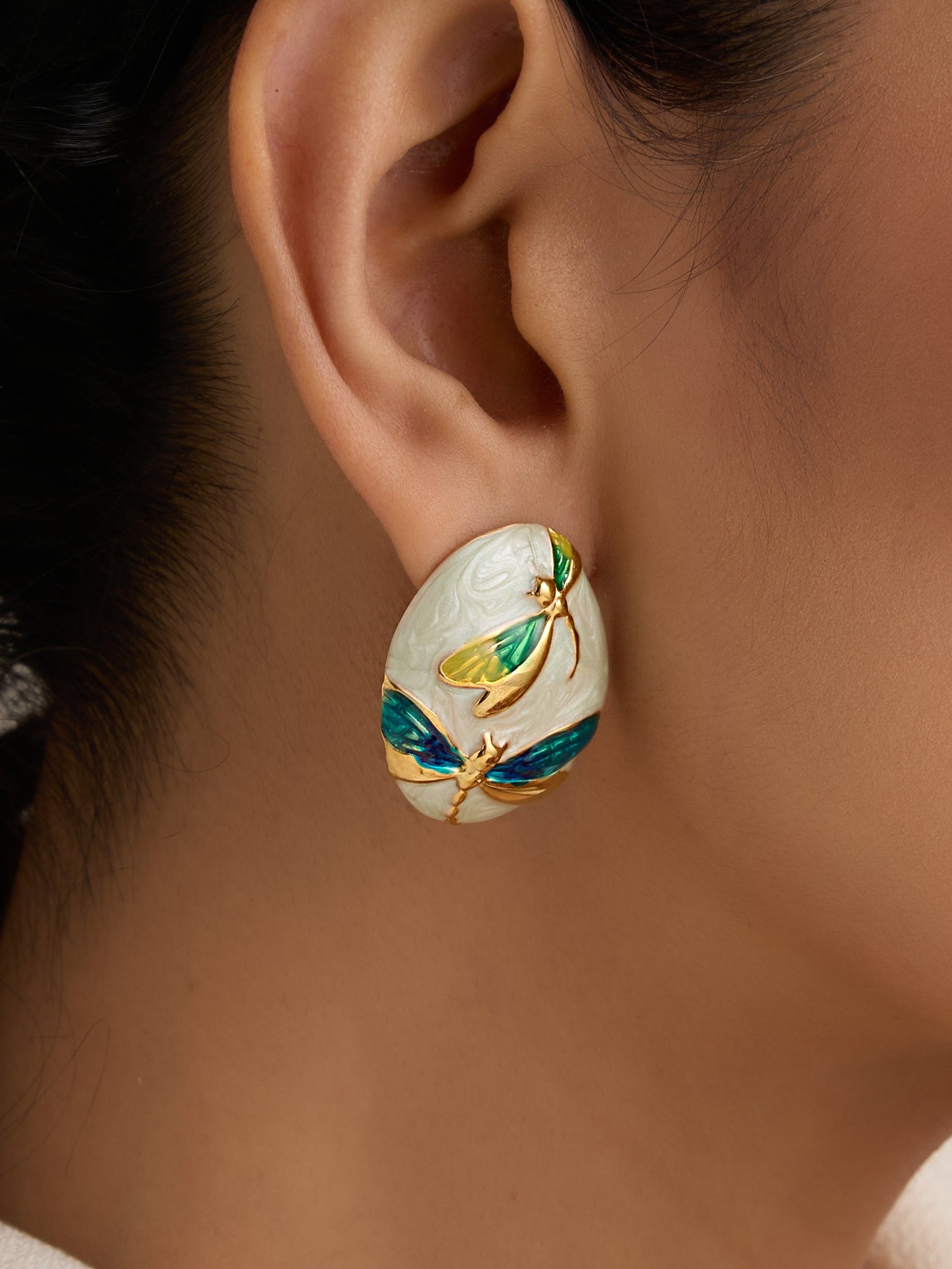 Close-up of a woman wearing an ornate earring with intricate design.